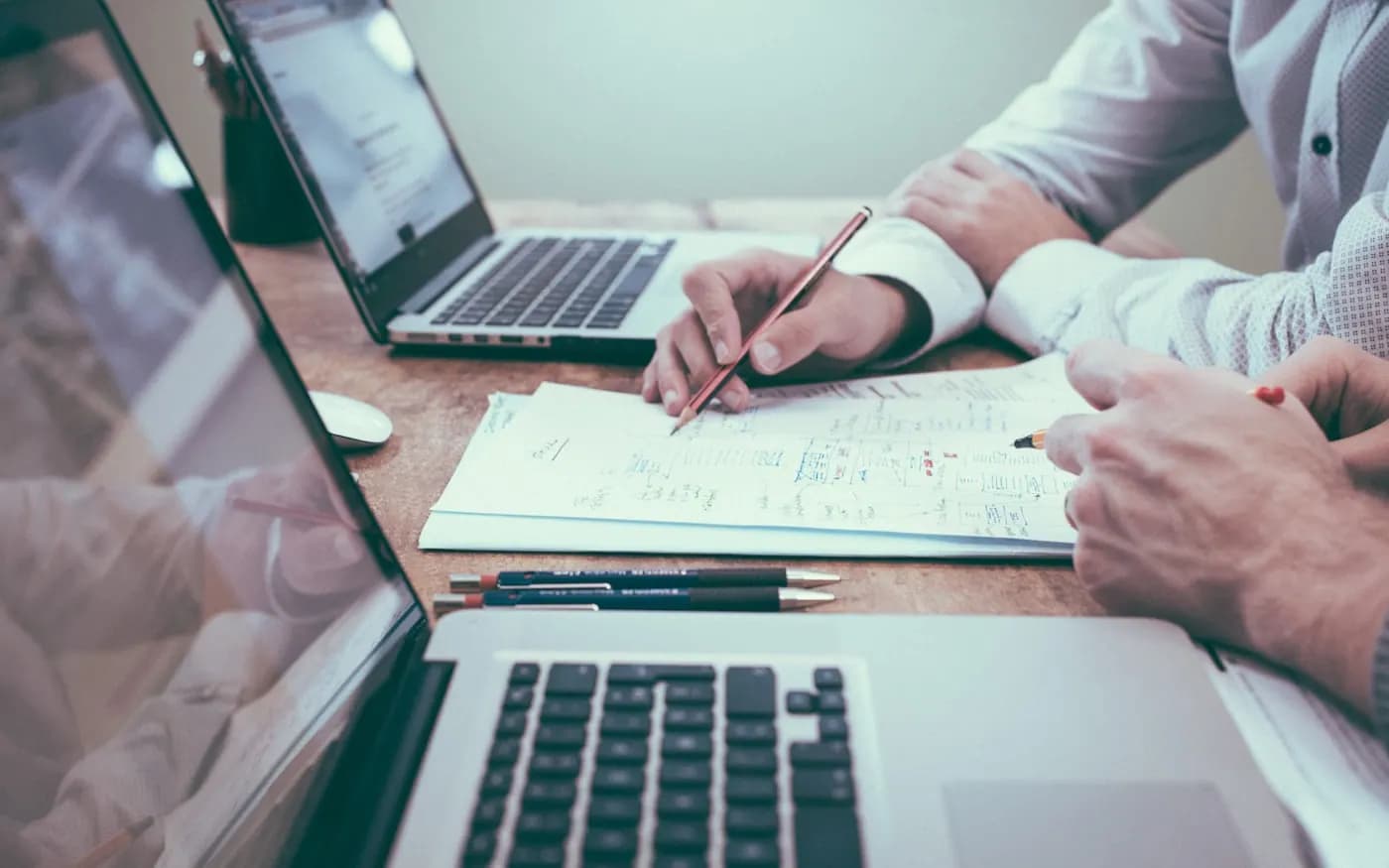 Wycena projektu rozpisywana na kartce obok laptopa