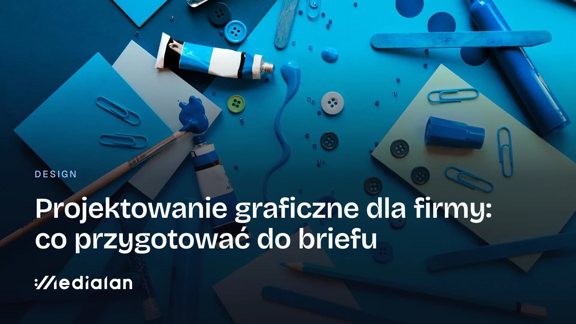 Niebieskie przybory projektowe na biurku: kartki, pisaki, farba w tubce, guziki i spinacze