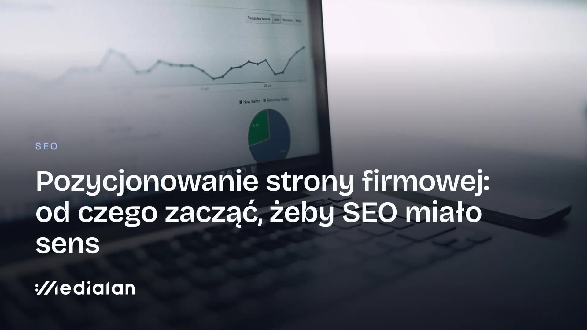 Laptop z wykresem ruchu i statystykami odwiedzin na ekranie, obok smartfon na jasnym biurku
