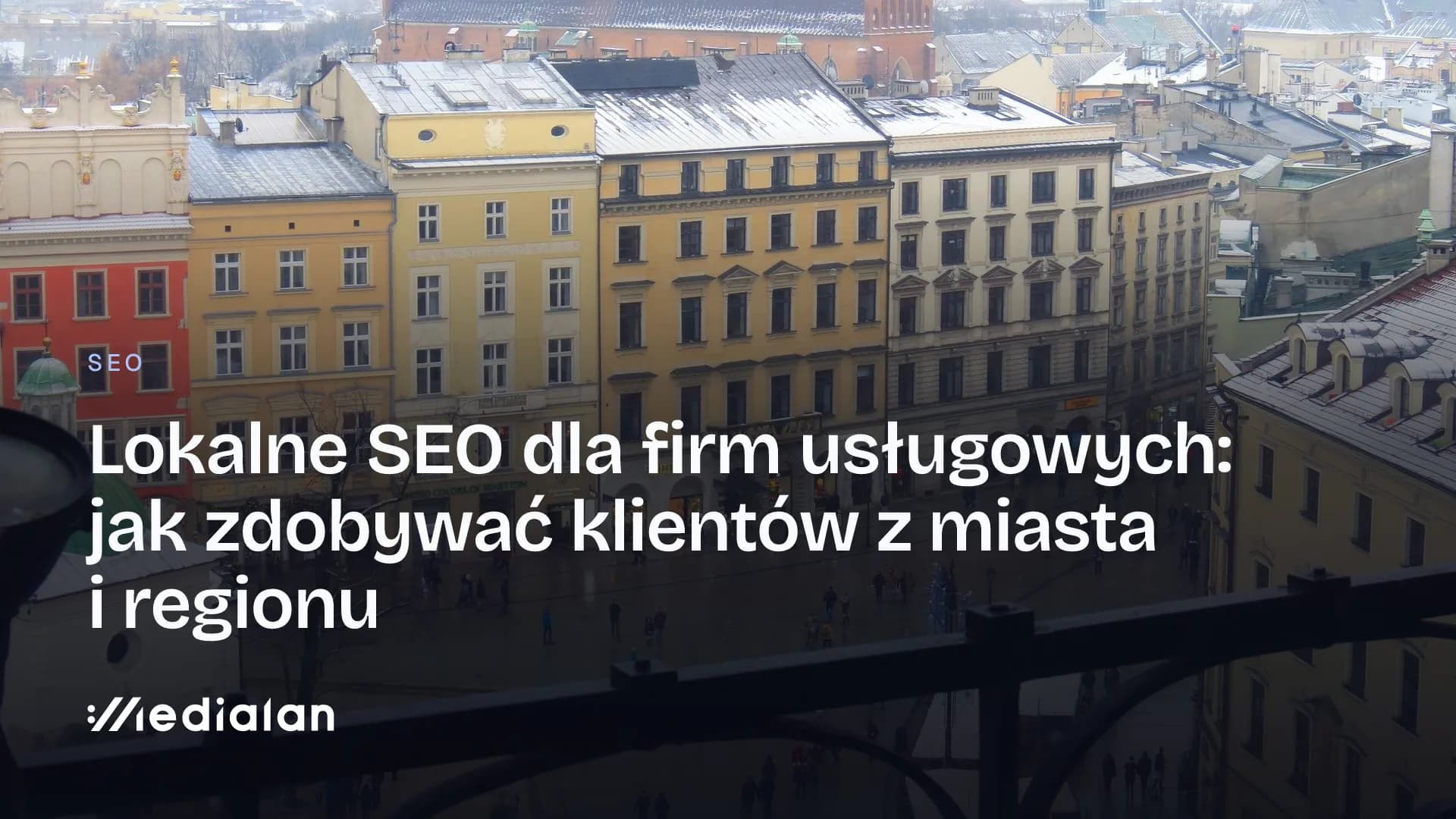Widok z góry na pierzeję Rynku Głównego w Krakowie z kamienicami, lokalami usługowymi i przechodniami