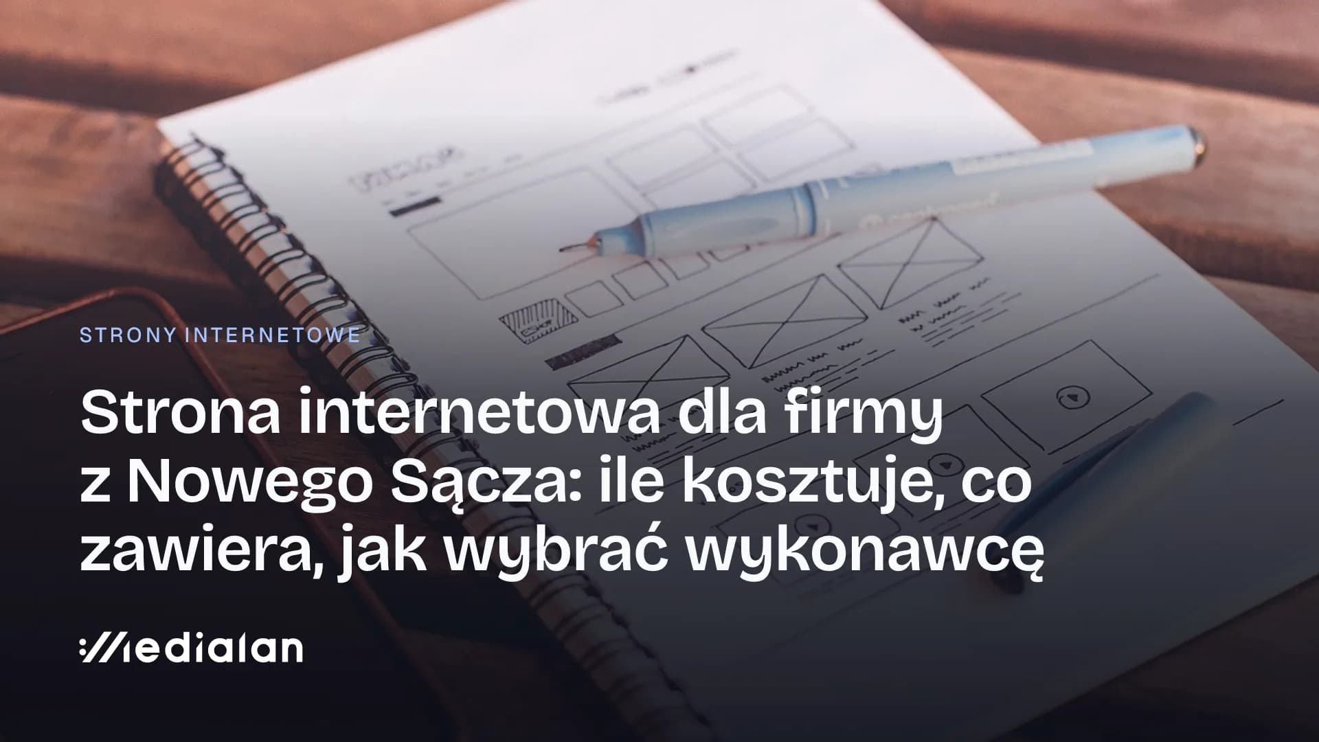 Notes ze szkicem makiety strony internetowej, długopis i smartfon na drewnianym stole