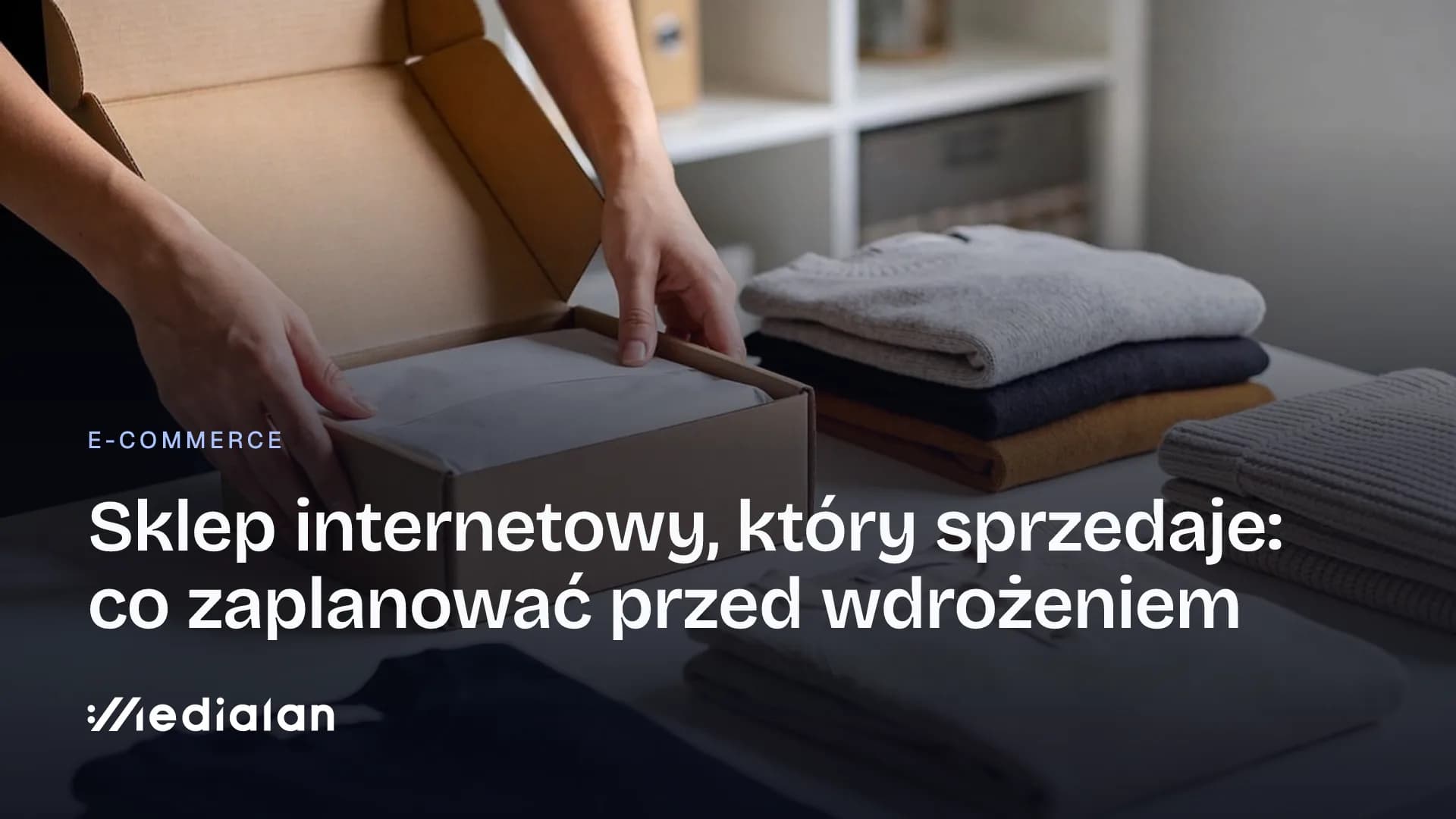 Dłonie pakują złożony sweter do kartonowego pudełka wysyłkowego, obok stosy ubrań na stole